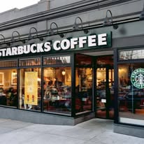 Starbucks Coffee storefront showcasing large windows, inviting customers inside for coffee and a social atmosphere.